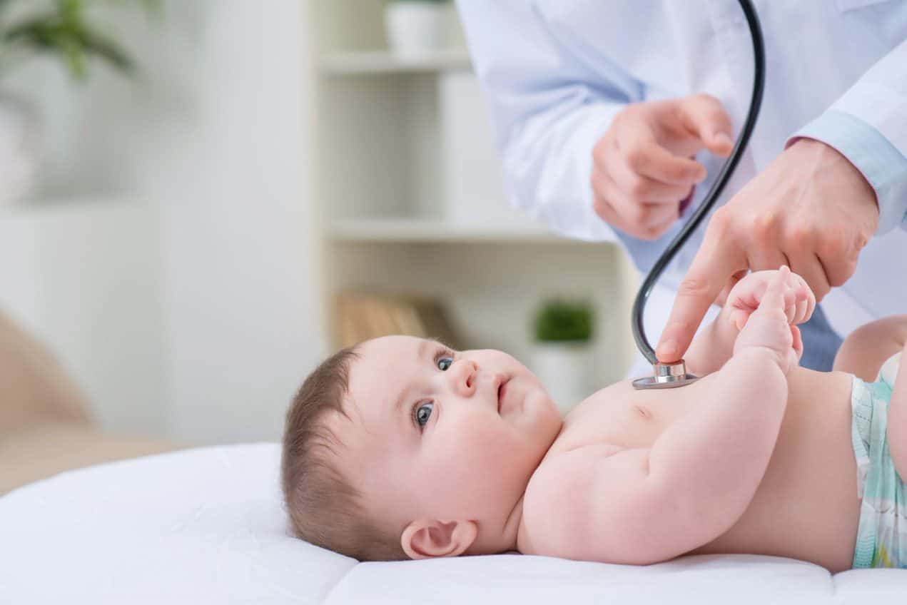 A baby is examined with a stethoscope.